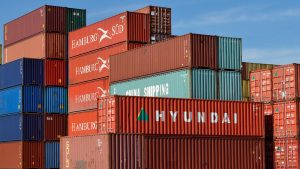 Hamburg Süd, Hyundai, China Shipping зэрэг янз бүрийн компаниудын өнгөлөг тээврийн чингэлэгүүд цэлмэг хөх тэнгэрийн эсрэг байрладаг. Улаан, ногоон, цэнхэр, улбар шар гэх мэт сүүдэрт агуулагдах эрч хүчтэй савнууд нь дэлхийн бизнес, предприемачествогийн динамик ертөнцийг бэлэгддэг. - Business.MN