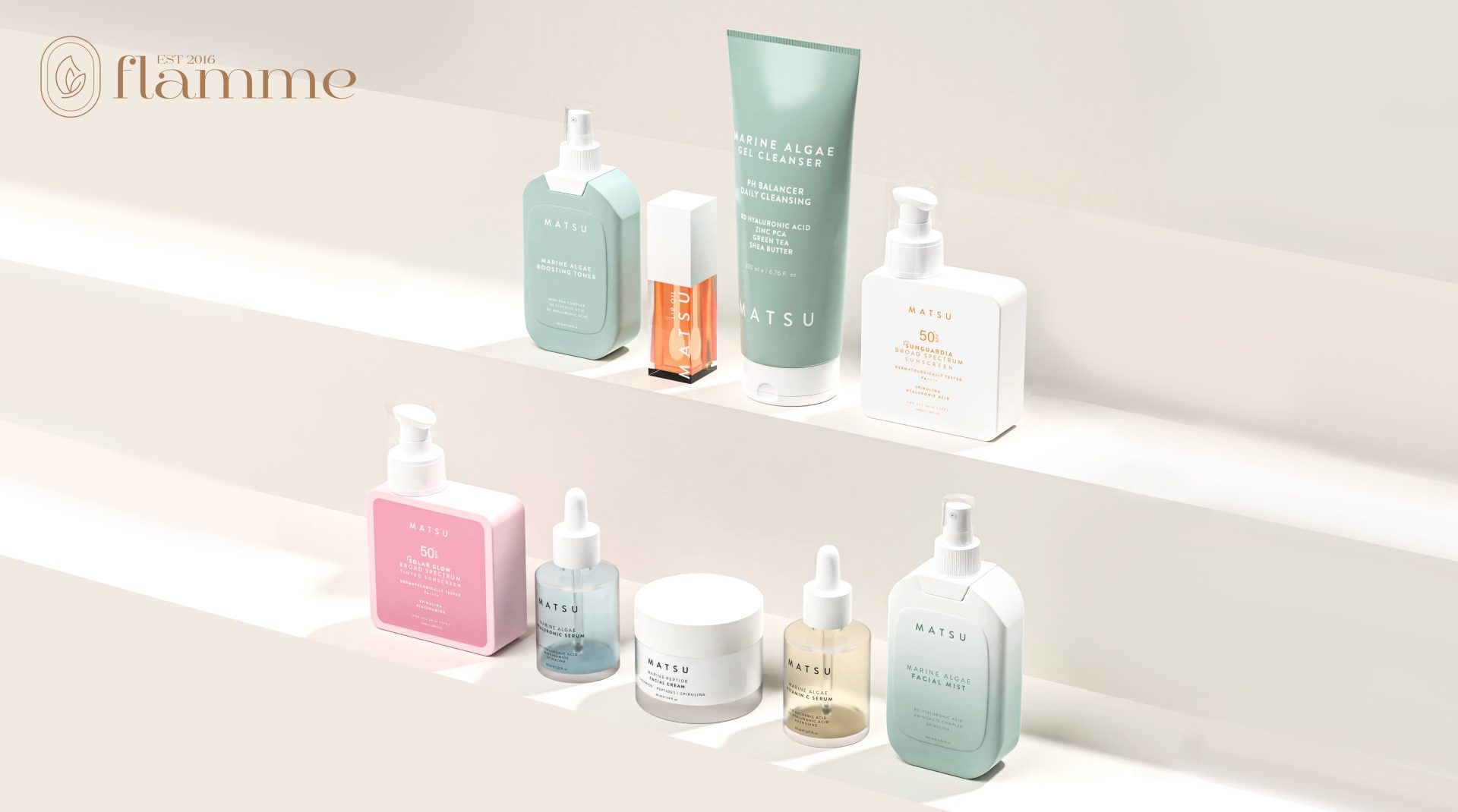 Skincare products displayed on a white surface in two rows, including cleansers, serums, moisturizers, and sunscreen, with varying pastel-colored packaging. A logo with the name "flamme" is seen in the top left corner.