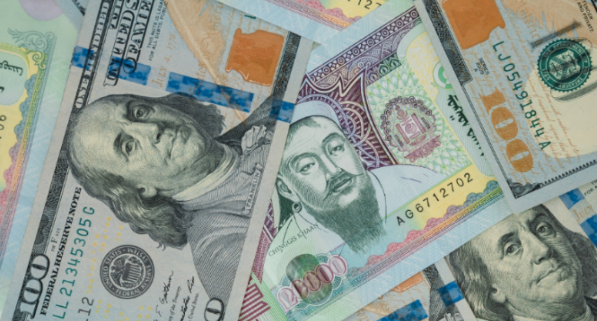 A scattered assortment of international currency notes, including U.S. dollars and Kazakhstan tenge. The notes feature prominent figures, colorful designs, and various denominations, showcasing diverse monetary systems.