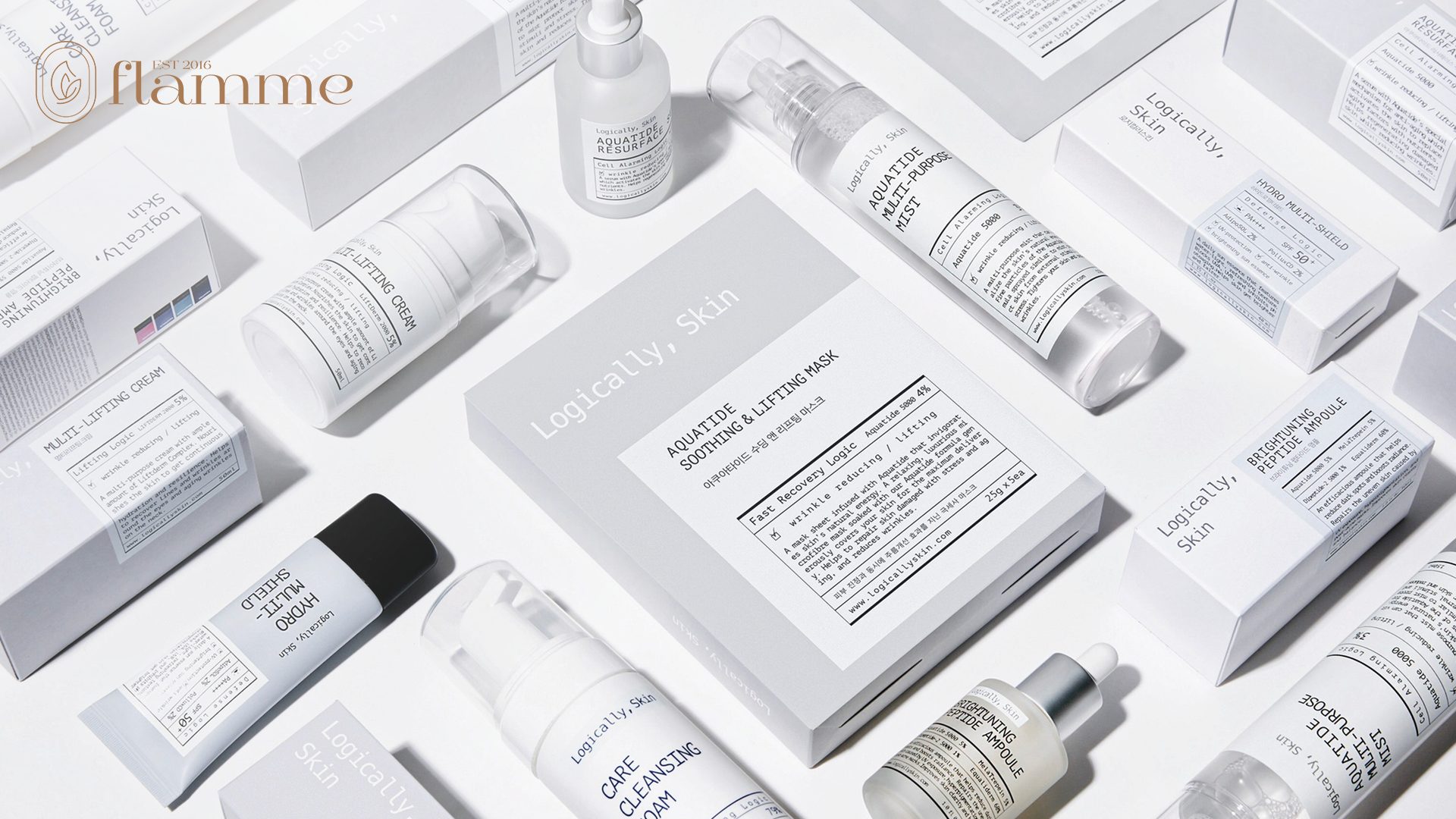 Various skincare products are arranged neatly on a white surface, including bottles, boxes, and tubes. The products are mainly white with minimalist labeling, creating a clean and organized aesthetic.